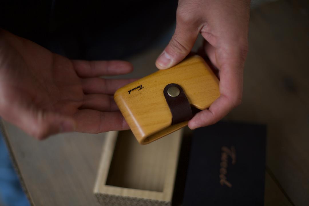 Handcrafted wooden wallet with natural wood grain and card slots on minimalist desk - eco-friendly sustainable accessory