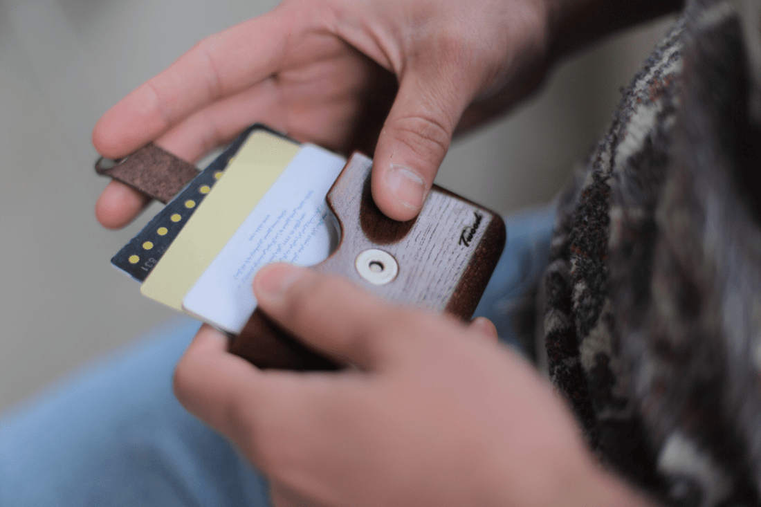 Handmade wooden wallet with card slots showing natural wood grain patterns and sustainable craftsmanship on wooden surface