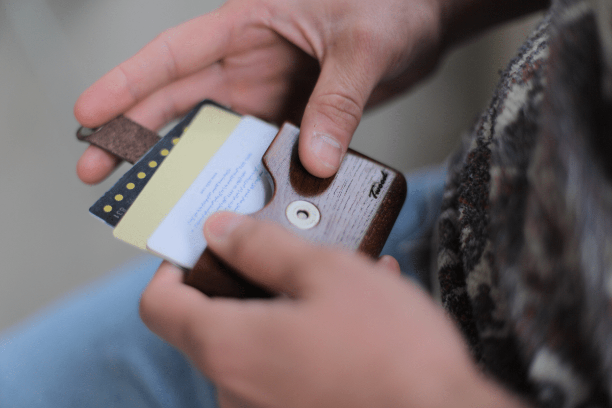 Handmade wooden wallet with card slots showing natural wood grain patterns and sustainable craftsmanship on wooden surface
