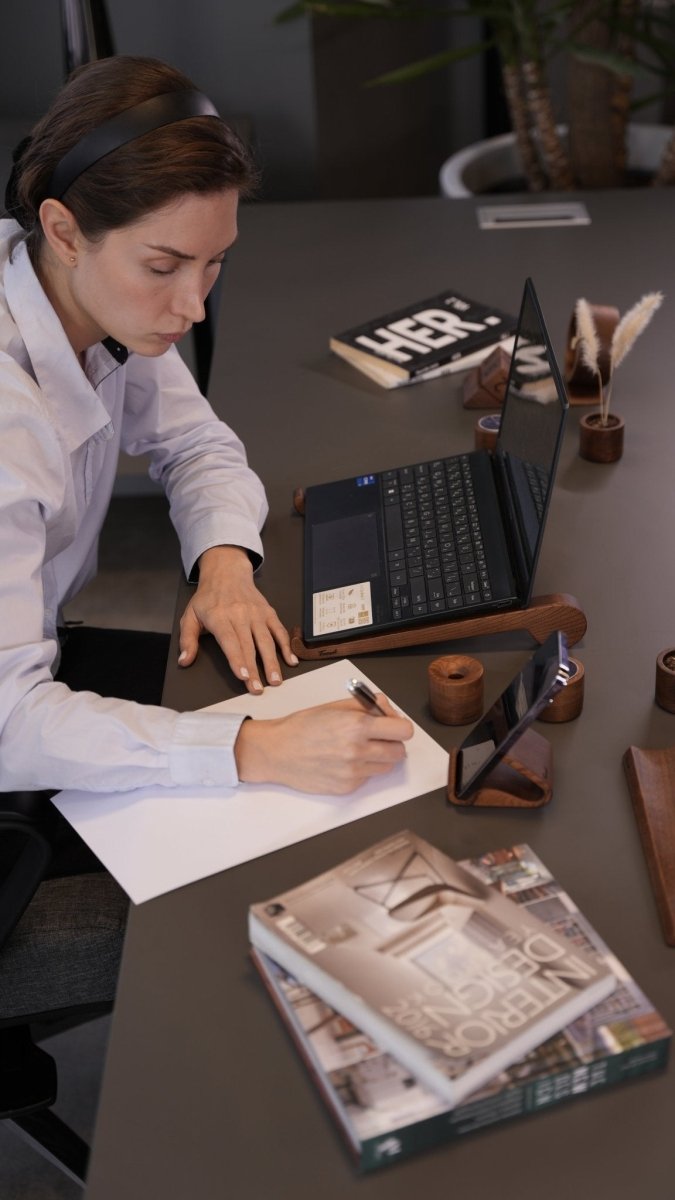 Organized productive home office workspace featuring handcrafted wooden desk accessories including organizer, laptop stand, and calendar on natural wood desk