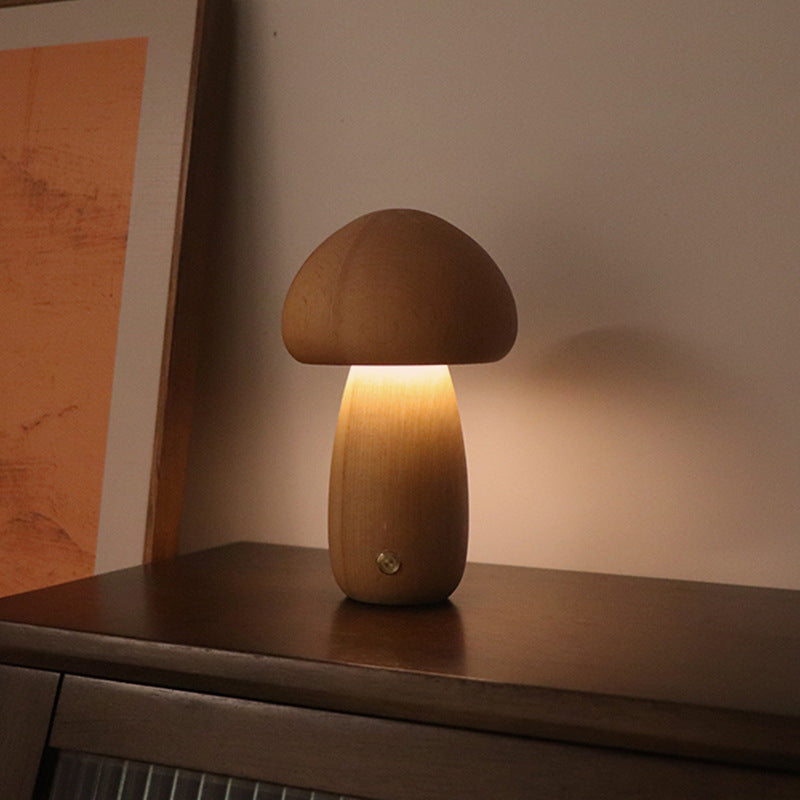Wooden mushroom lamp on a wooden surface with a warm glow